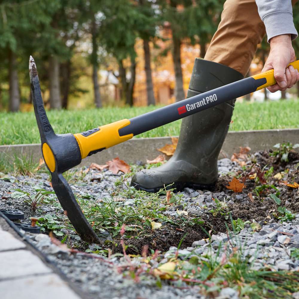 Pioche Garant Pro utilisée pour l’aménagement paysager, outil robuste idéal pour les sols durs et rocailleux
