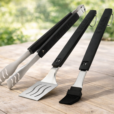 Ensemble de trois ustensiles BBQ Napoléon 70034 en acier inoxydable sur fond neutre, gros plan poignée et spatule